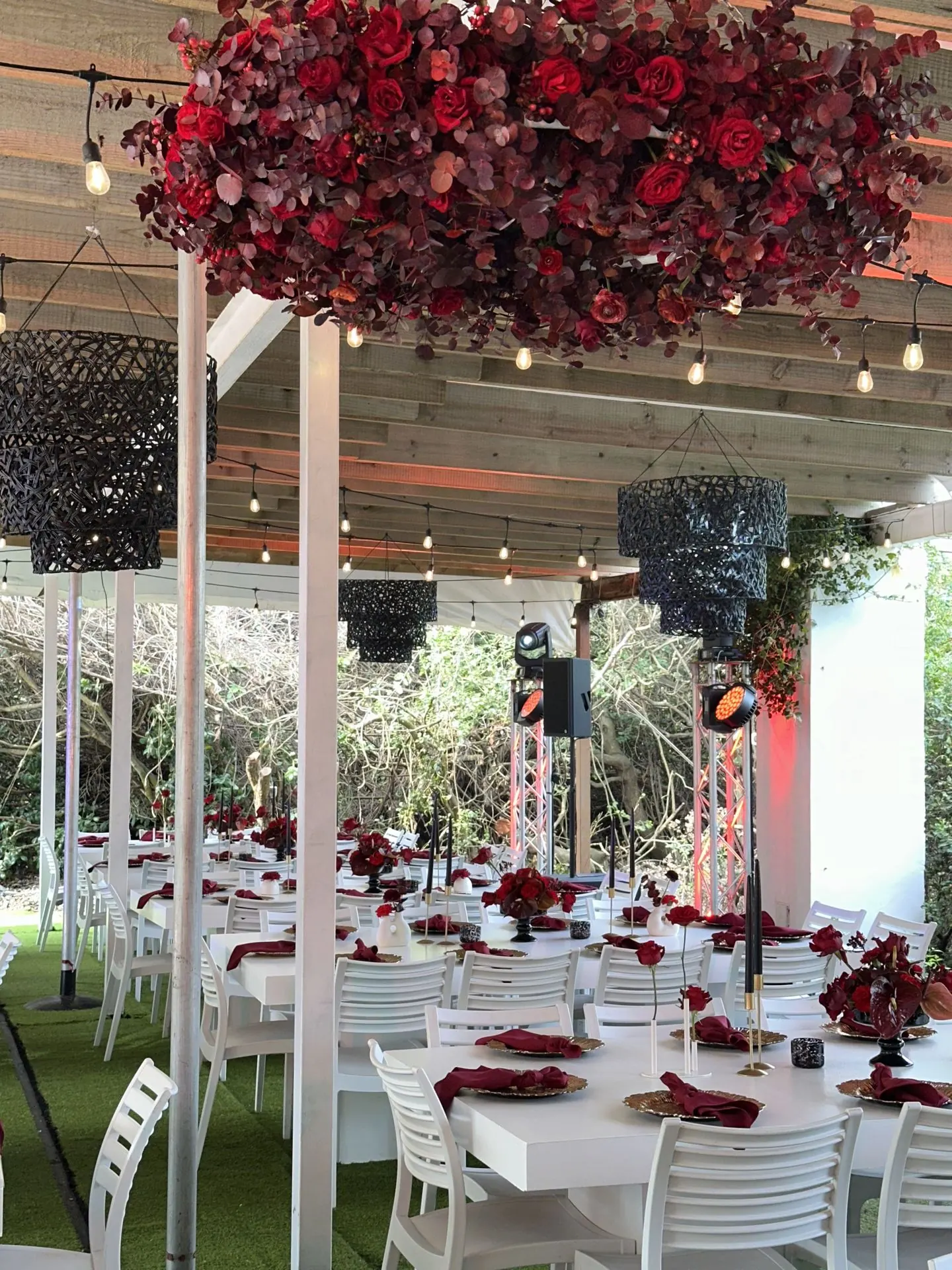 Suspended crimson florals over year-end banquet tables